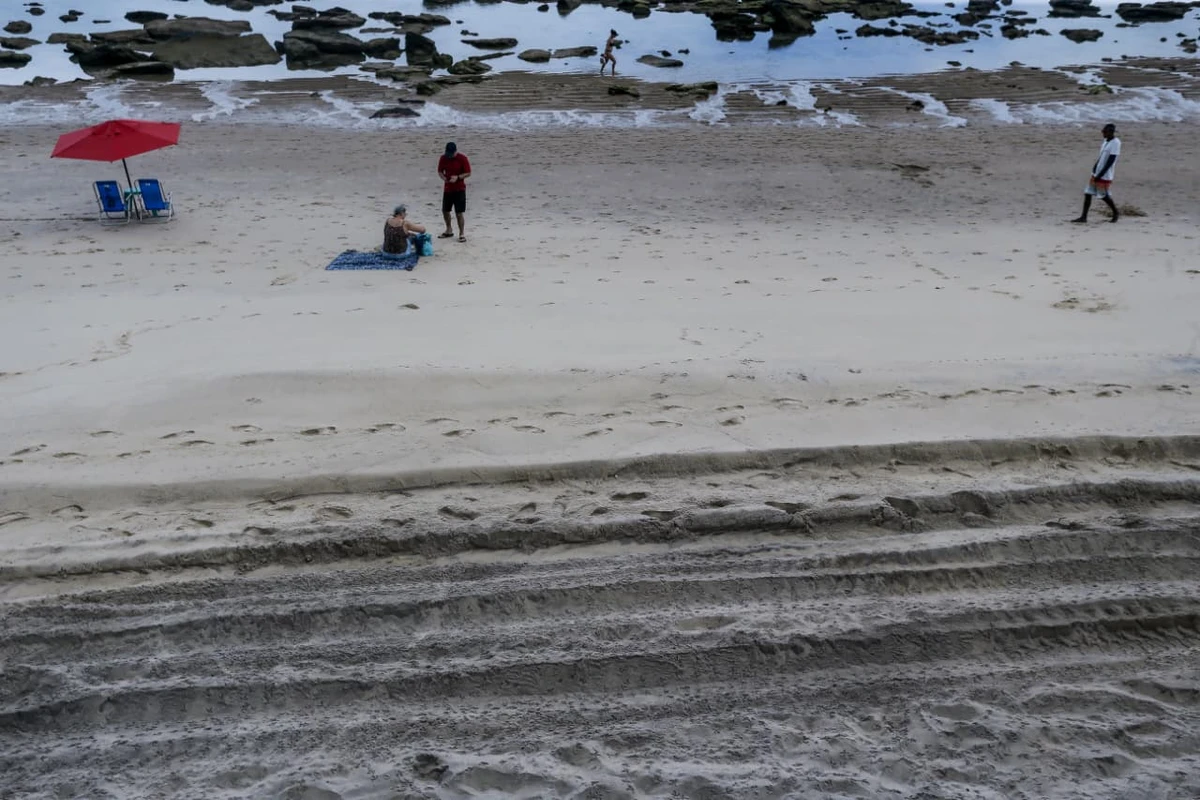 Areia da praia da Barra tem chamado atenção por coloração escura por Arisson Marinho/CORREIO