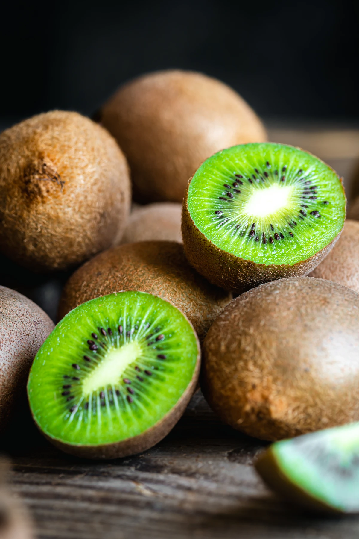 Ripe fruits of kiwi cut and whole on a wooden background, close -up. por Reprodução (Redes Sociais/Freepik)