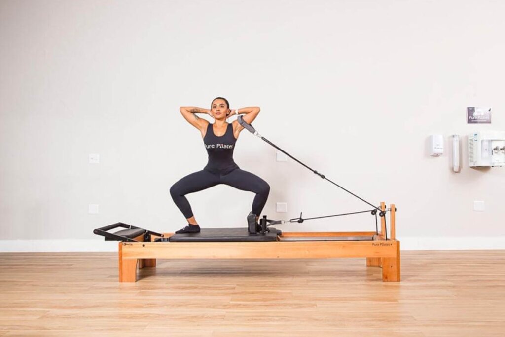 O agachamento sumô no reformer ajuda a melhorar a flexibilidade articular de quadril (Imagem: Divulgação | Pure Pilates)