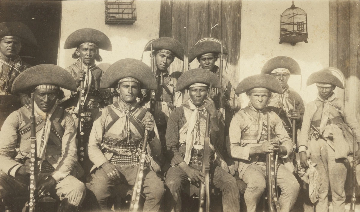 Bando de Lampião. Na esquerda, Lampião. No outro lado, Volta Seca, em pé e com menos de 11 anos completos