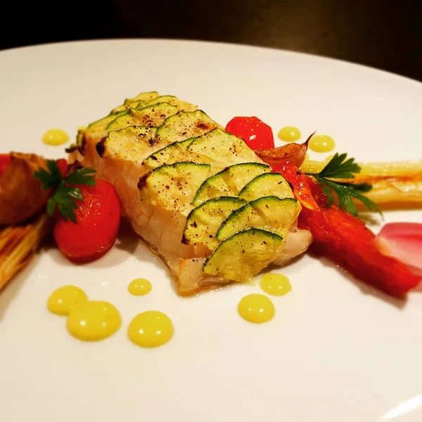 Badejo com escamas de abobrinha, tomate, alho poró, alho, cebola roxa e molho holandês por Reprodução/ Redes sociais