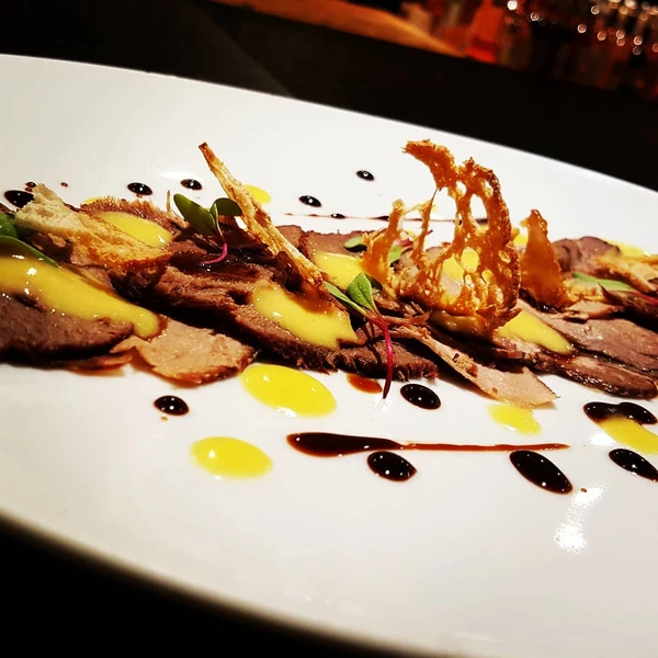 Carpaccio de língua, redução de malbec, torradas e maionese de bacon por Reprodução/ Redes sociais