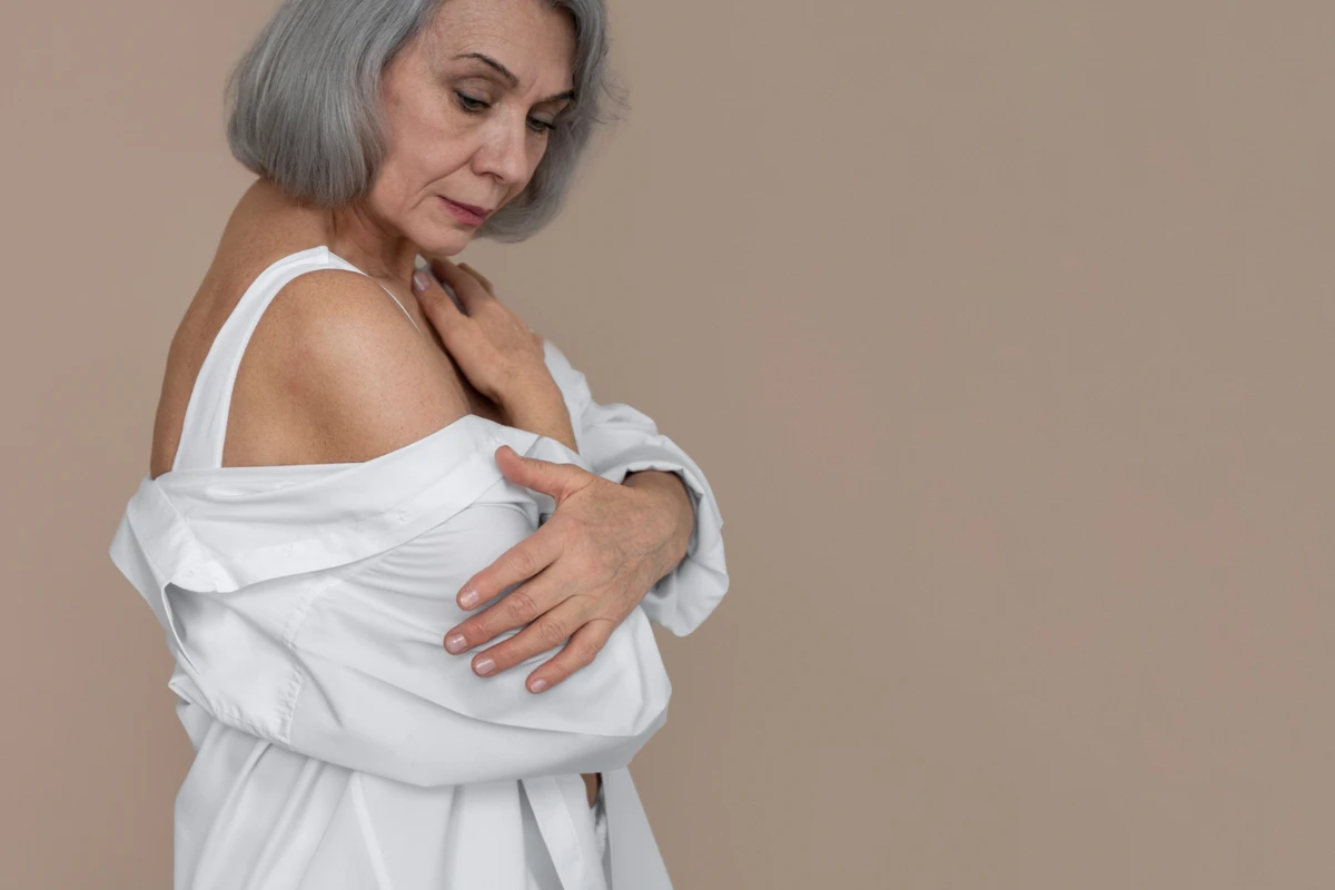 Mulher idosa segurando os seios