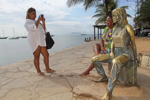 Turistas e moradores tiram foto ao lado de estátua de atriz