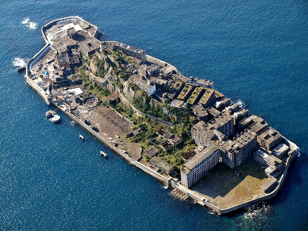Gunkanjima atualmente é um deserto de escombros onde apenas o vento sopra entre os apartamentos vazios por Wikipedia/kntrty