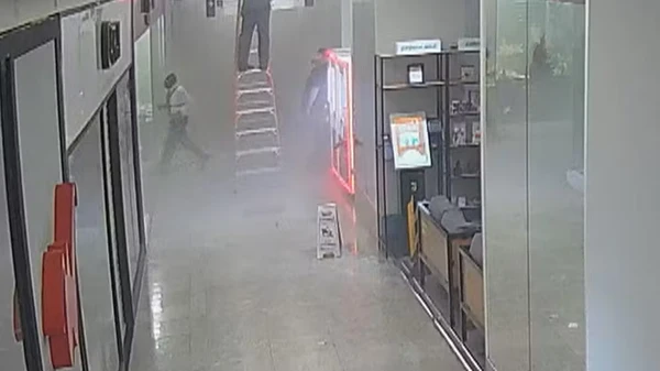 Sem paletó, ele entra pela última vez na loja, na última imagem em que aparece antes de ser retirado desacordado por Reprodução