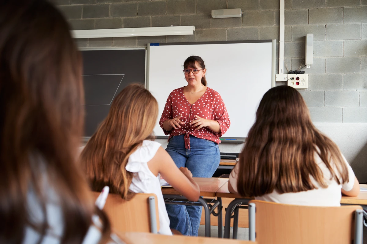 Professora lecionando na frente de estudantes