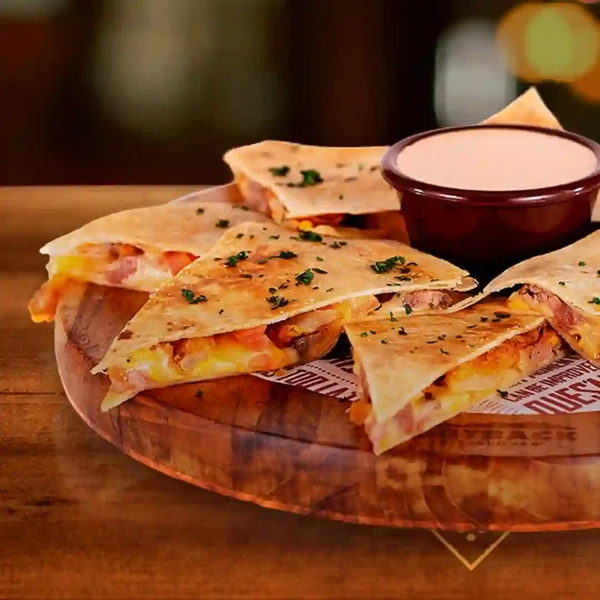 Chook’n Dillas: Quesadilla recheada com tiras de frango, coberta com bacon, champignons e queijo. por Divulgação