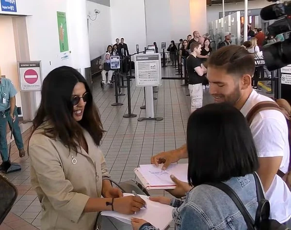 Priyanka Chopra ao lado dos supostos fãs falsos por Reprodução