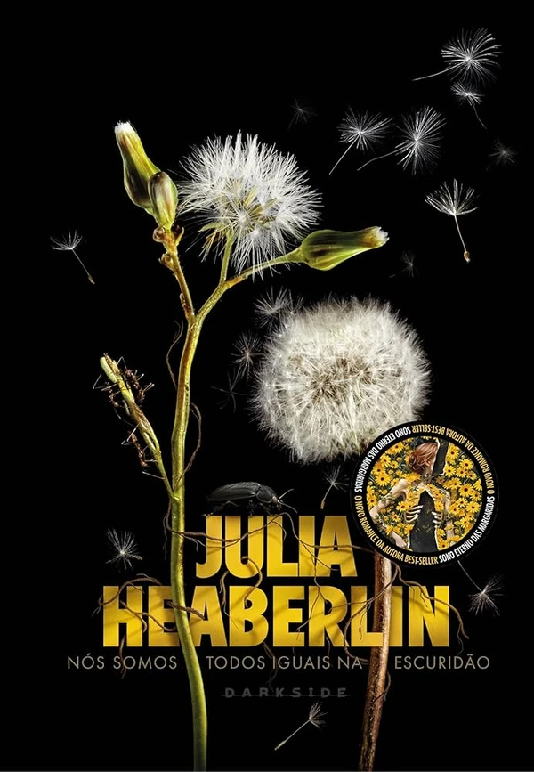 Nós somos todos iguais na escuridão, de Julia Heaberlin (Darkside). Já se passou uma década desde que a popular líder de torcida Trumanell Branson, de 19 anos, desapareceu da fazenda onde morava com a família, restando apenas a marca ensanguentada de uma das suas mãos gravada na parede de casa. Cartazes com seu rosto ainda assombram as paredes da igreja, da delegacia e da escola com a promessa de encontrá-la. A descoberta de uma menina abandonada à beira da estrada em um belo campo florido de dentes-de-leão ameaça desvelar os segredos há muito enterrados de um caso não resolvido em uma cidade do Texas. por Reprodução