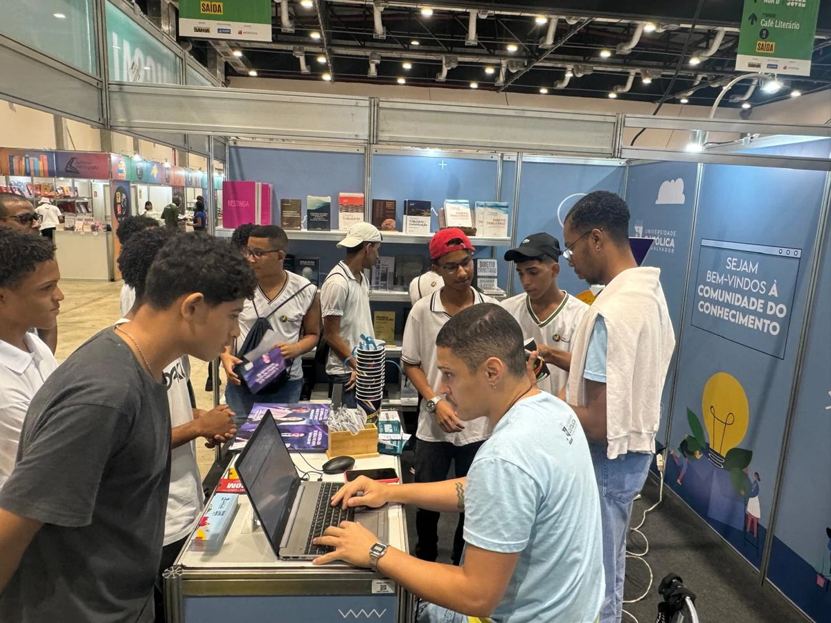 Visitantes exploram o acervo de livros no estande da UCSal durante a Bienal do Livro Bahia 2024, no Centro de Convenções Salvador por Divulgação/UCSal
