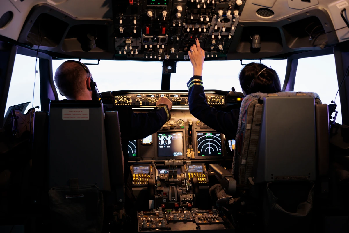 Captain and woman copilot getting ready to fly airplane and takeoff with dashboard navigation in cockpit command. Airline crew fixing altitude level and with control panel buttons, flying plane. por Divulgação