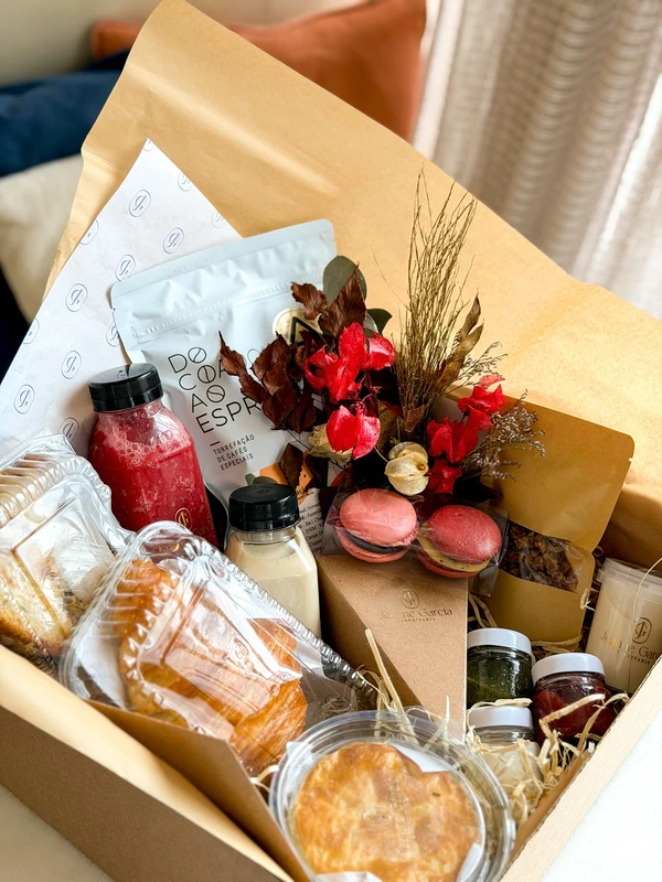 Se a ideia é começar o dia bem — e sem louça — as cestas da Jeanne Garcia Confeitaria são praticamente um “café da manhã pronto” com clima afetivo. por Divulgação