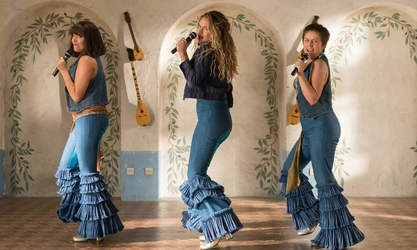 Mamma Mia: Lá Vamos Nós de Novo!, filme de 2018. Em Mamma Mia! Lá Vamos Nós de Novo, um ano após a morte de Donna (Meryl Streep), sua filha Sophie (Amanda Seyfried) está prestes a reinaugurar o hotel da mãe, agora totalmente reformado. Para tanto convida seus três "pais", Harry (Colin Firth), Sam (Pierce Brosnan) e Bill (Stellan Skarsgard) e as eternas amigas da mãe, Rosie (Julie Walters) e Tanya (Christine Baranski), ao mesmo tempo em que precisa lidar com a distância do marido Sky (Dominic Cooper), que está fazendo um curso de hotelaria em Nova York. O reencontro serve para desenterrar memórias sobre a juventude de Donna (Lily James), no final dos anos 70, quando ela resolve se estabelecer na Grécia. Disponível na Netflix, GloboPlay, Telecine, AppleTV.  por Reprodução