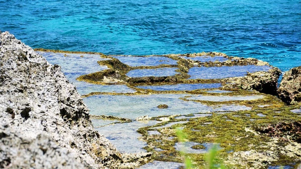 Mesmo cercada por mar azul, a ilha lembra que nem toda paisagem bonita consegue esconder o que aconteceu sobre ela