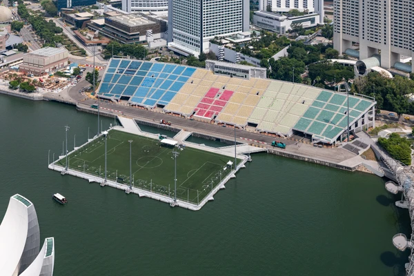 The Float at Marina Bay — Singapura: Montado sobre a água em Singapura, o The Float at Marina Bay é uma arena flutuante cercada pela paisagem futurista da cidade. Com capacidade para cerca de 30 mil pessoas, o estádio virou símbolo de engenharia ousada e oferece uma experiência rara para eventos esportivos.
 por Reprodução