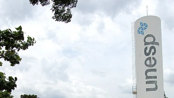 Campus da Unesp em Bauru tem torre com identificação da universidade e prédios acadêmicos ao fundo por Hernani Arruda Monteiro da Silva / Wikimedia Commons
