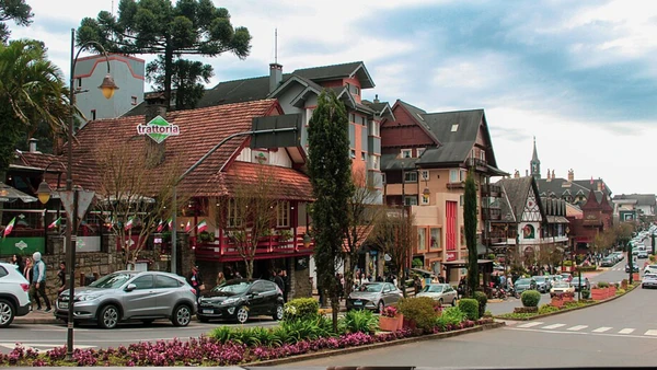 Vista de Gramado mostra ruas floridas, arquitetura serrana e movimento turístico no centro da cidade