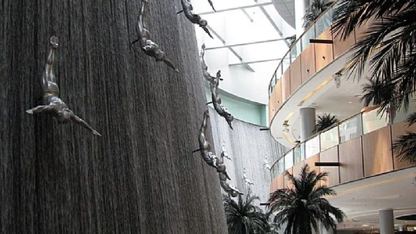 Dubai Mall Waterfall tem esculturas de mergulhadores e queda d’água em área interna do shopping por Peter Dowley / Wikimedia Commons
