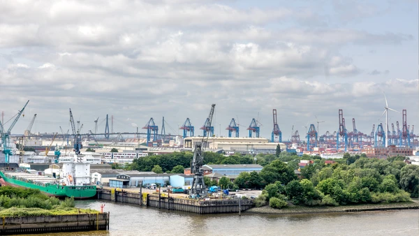 Navio cargueiro e guindastes reforçam o peso do comércio internacional na discussão sobre a ferrovia bioceânica por Freepik