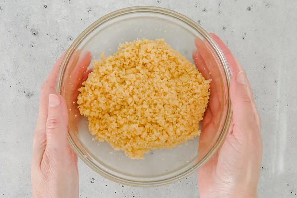 Misture com as pontas dos dedos:  1 pacote de biscoito cream cracker triturado (130 g) + 3 colheres (sopa) de manteiga ou margarina por Shutterstock e divulgação