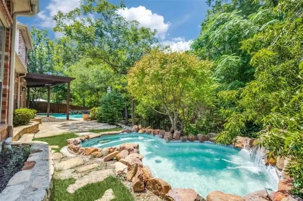 Área externa da casa chama atenção pelo estilo resort e pela piscina cercada por pedras por Reprodução