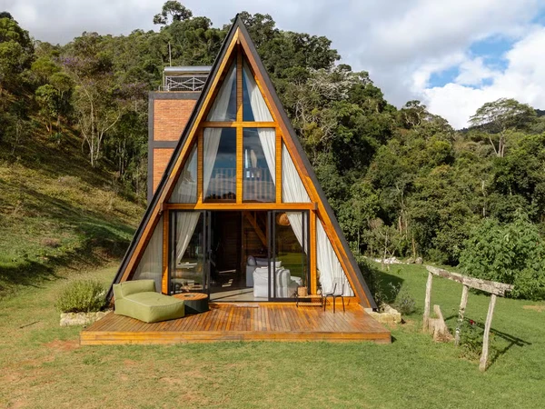 Cabana de Yanna Lavigne e Bruno Gissoni aposta em arquitetura de vidro, sauna a lenha e vista para a Serra da Mantiqueira por Manuel Sá