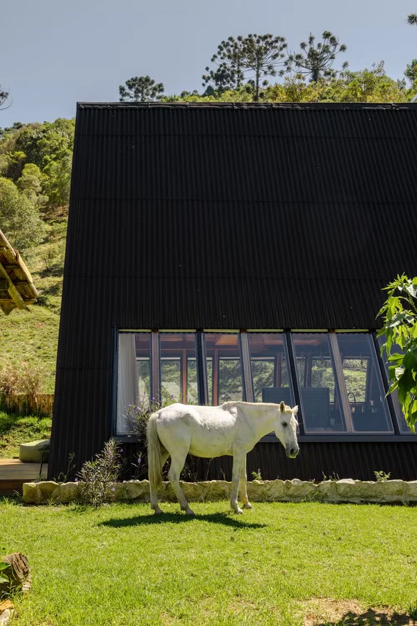 Cabana de Yanna Lavigne e Bruno Gissoni aposta em arquitetura de vidro, sauna a lenha e vista para a Serra da Mantiqueira por Manuel Sá