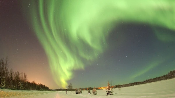 A aurora boreal nasce desse processo, quando partículas solares barradas pelo campo interagem com gases na alta atmosfera por Senior Airman Joshua Strang / Wikimedia Commons