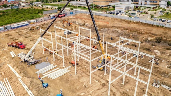 Em vez de levantar paredes com tijolo e cimento, a obra funciona como uma montagem técnica com peças mais padronizadas