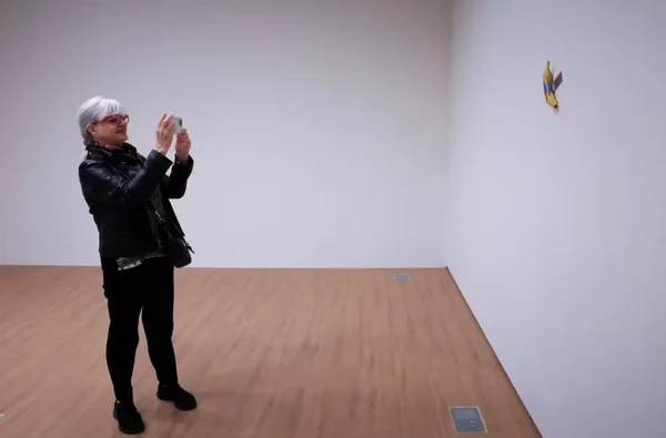 Visitante de museu francês fotografa a obra com banana e fita adesiva do italiano Cattelan por Reprodução/AFP