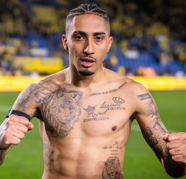 A família também aparece nas tatuagens de Raphinha que tatuou o nome dos pais, Lisiane e Rafael, no peito, acompanhados das datas de nascimento em números romanos. O jogador ainda registrou a data de nascimento do filho, em 6 de maio de 2023. por Reprodução | Redes Sociais